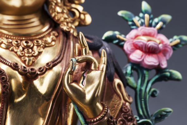 The gilded form of Green Tara with flower, made of metal. Executed in the Tibetan tradition.